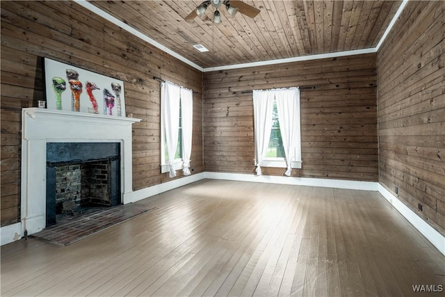 221 3rd Ct SW, Fayette, AL 35555 - unfurnished living room featuring a fireplace with raised hearth, hardwood / wood-style floors, a ceiling fan, wood walls, and wood ceiling