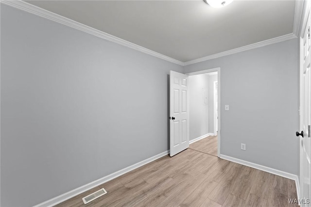 unfurnished bedroom with light wood-style flooring, visible vents, crown molding, and baseboards