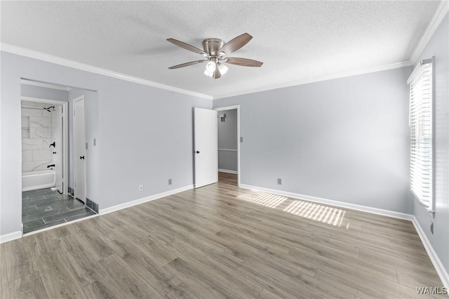 unfurnished bedroom featuring wood finished floors, multiple windows, and a textured ceiling