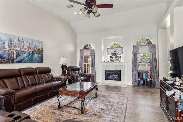 living room with ceiling fan, lofted ceiling, hardwood / wood-style floors, and a fireplace