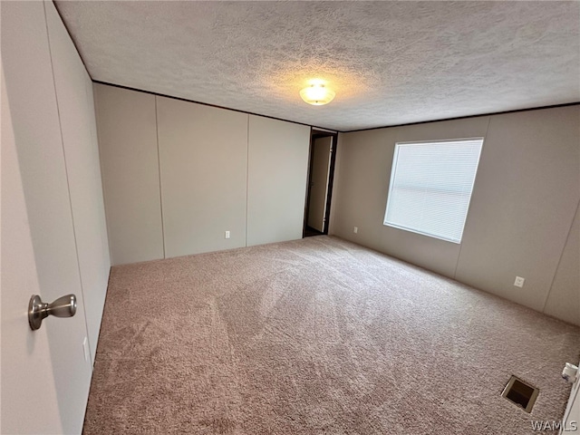 empty room featuring a textured ceiling and carpet floors