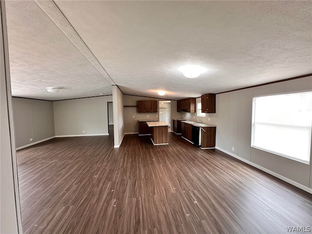 kitchen featuring a textured ceiling, a kitchen island, dark wood-type flooring, and sink