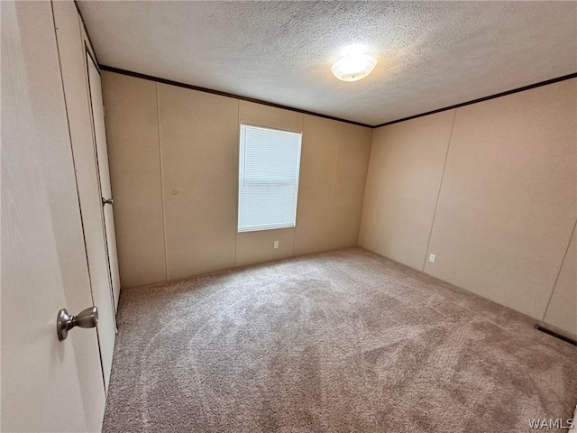 unfurnished room with light carpet and a textured ceiling