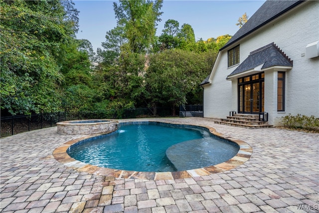 view of swimming pool with pool water feature, an in ground hot tub, and a patio