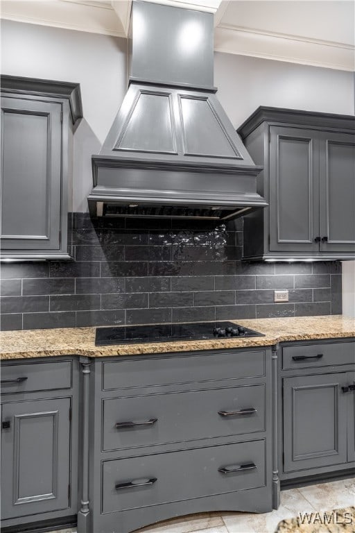 kitchen with gray cabinets, decorative backsplash, black electric stovetop, and custom range hood