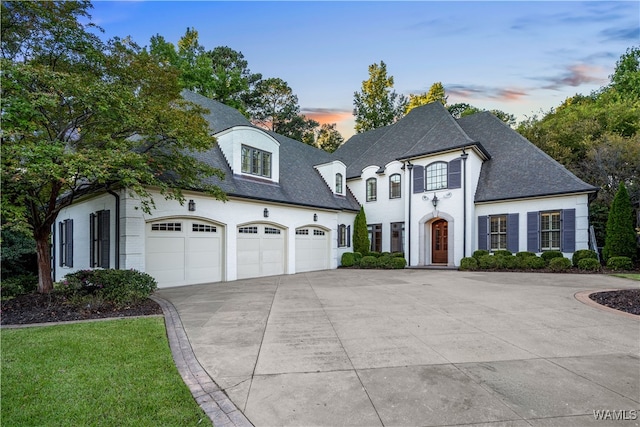 french country inspired facade featuring a garage