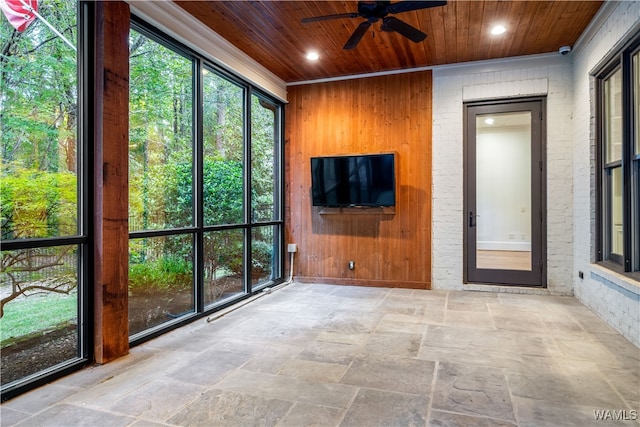 unfurnished sunroom with ceiling fan and wooden ceiling