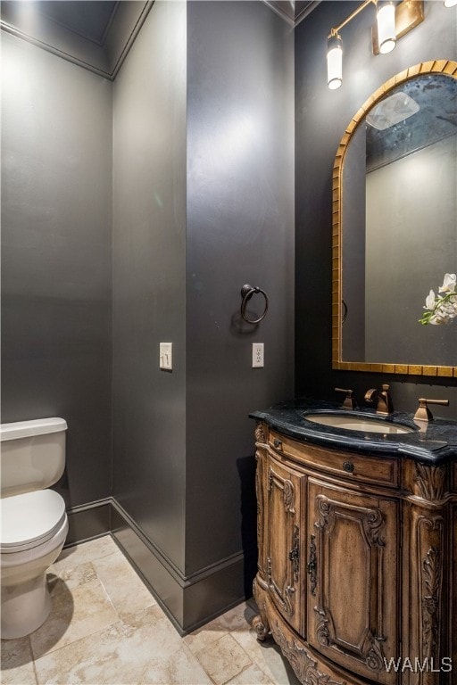 bathroom with vanity, ornamental molding, and toilet