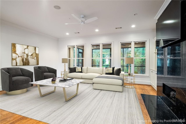 living room with ceiling fan, light hardwood / wood-style floors, and ornamental molding