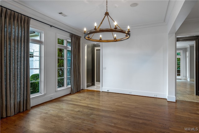 unfurnished dining area featuring ornamental molding, dark wood-type flooring, and an inviting chandelier