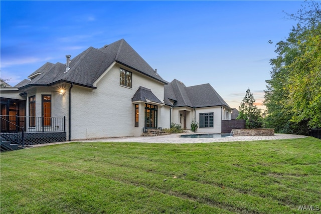 french country style house with a patio area and a yard