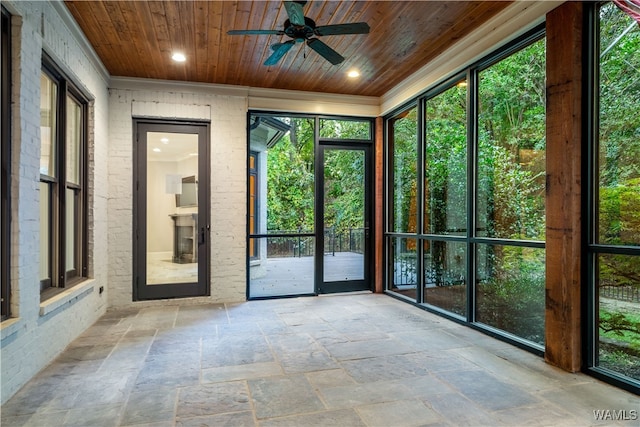 unfurnished sunroom with ceiling fan and wood ceiling