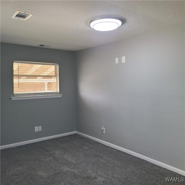 unfurnished room featuring a textured ceiling, dark colored carpet, visible vents, and baseboards