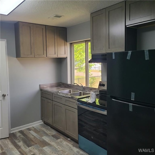 kitchen featuring a sink, freestanding refrigerator, gray cabinetry, light wood-style flooring, and electric range