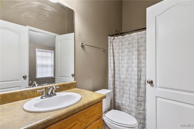 bathroom featuring vanity, a shower with shower curtain, and toilet