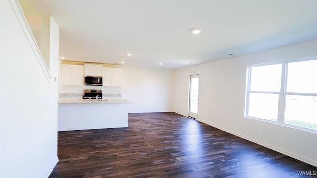 unfurnished living room with dark wood-type flooring