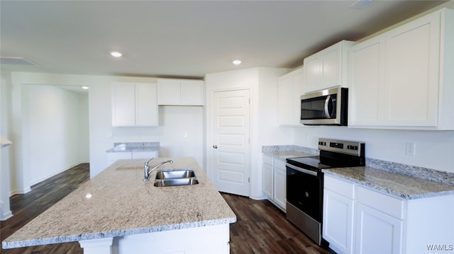 kitchen with dark wood-type flooring, stainless steel appliances, a center island with sink, and sink