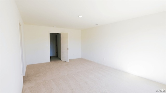 unfurnished room featuring light colored carpet