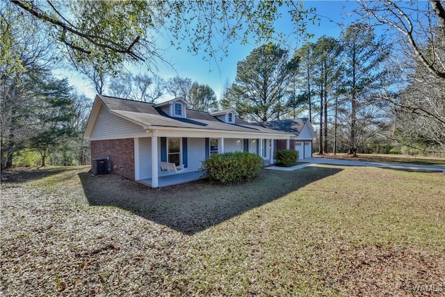 view of side of property featuring a lawn, central AC unit, and covered porch