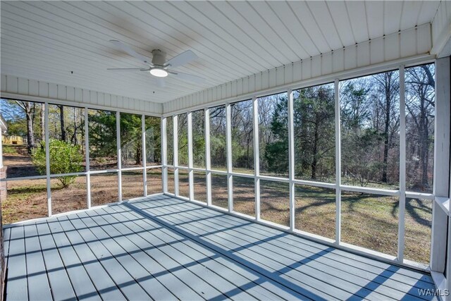 unfurnished sunroom with ceiling fan