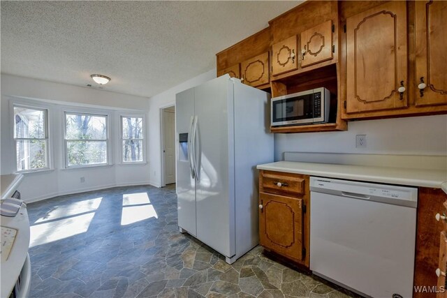 kitchen featuring white appliances and a textured ceiling