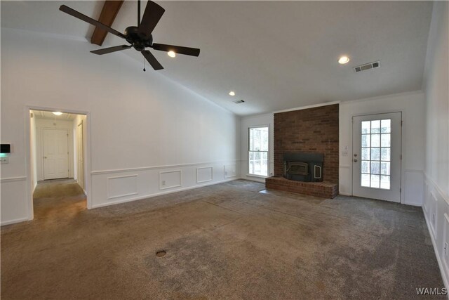 unfurnished living room featuring carpet, beam ceiling, plenty of natural light, and ceiling fan