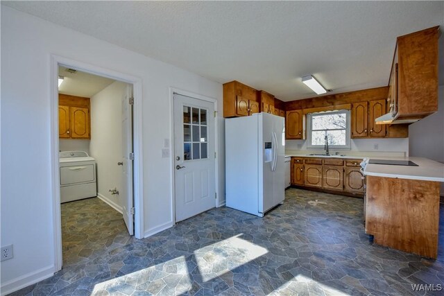 kitchen with white refrigerator with ice dispenser, sink, and washer / clothes dryer