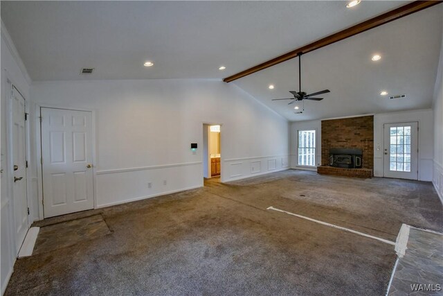 unfurnished living room featuring vaulted ceiling with beams, ceiling fan, carpet floors, and a wood stove