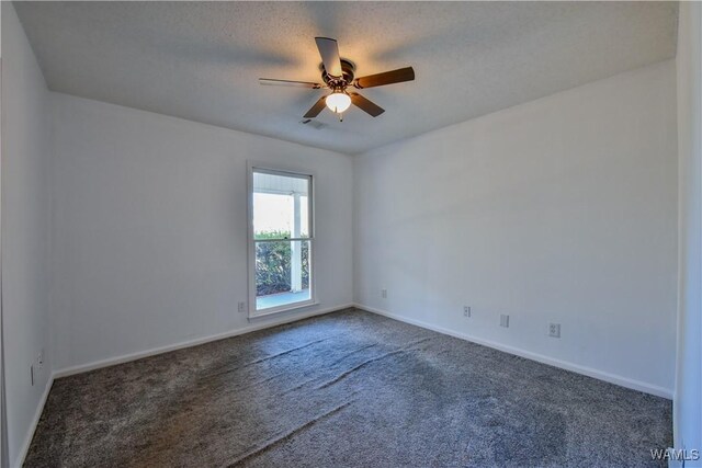 carpeted spare room featuring a textured ceiling and ceiling fan