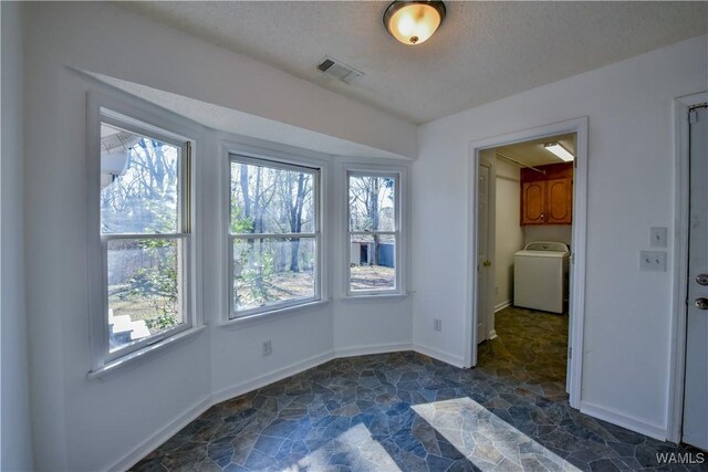 spare room featuring a textured ceiling and washer / clothes dryer