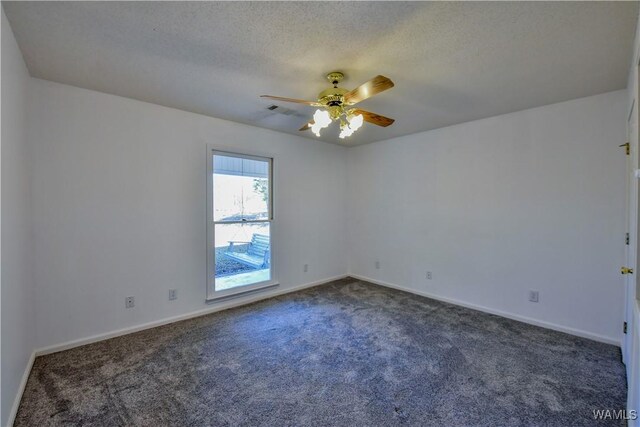 carpeted spare room featuring a textured ceiling and ceiling fan