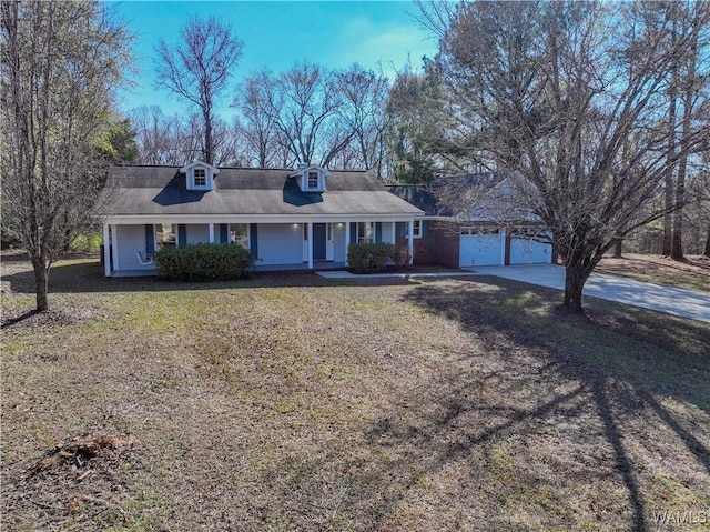 ranch-style house featuring a garage, covered porch, and a front lawn