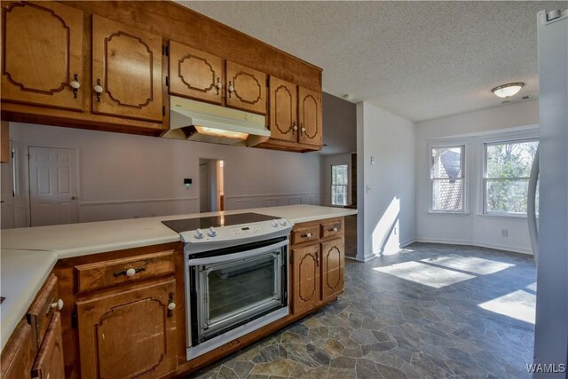 kitchen with stainless steel fridge, electric range, and a textured ceiling