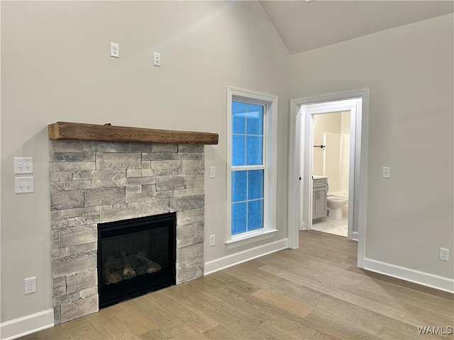 unfurnished living room with light hardwood / wood-style floors, lofted ceiling, and a fireplace