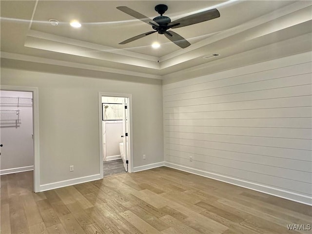 spare room featuring hardwood / wood-style flooring, a raised ceiling, and ceiling fan