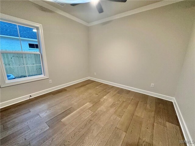 spare room featuring ceiling fan, wood-type flooring, and ornamental molding