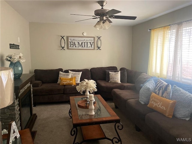 living room featuring carpet, ceiling fan, and a fireplace