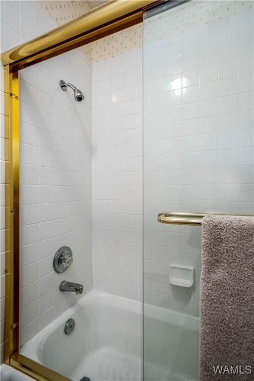 bathroom with bath / shower combo with glass door