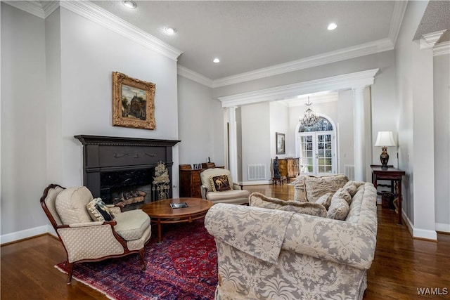 living area with wood finished floors, visible vents, baseboards, decorative columns, and a fireplace