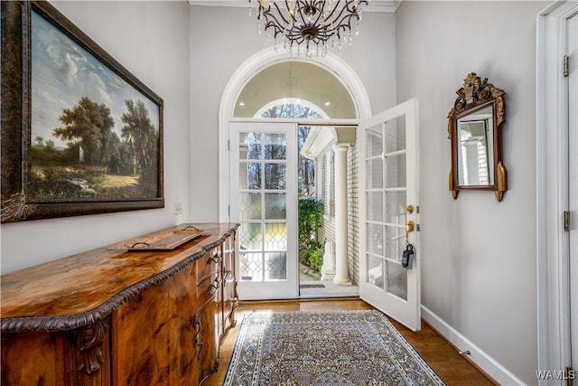 entryway featuring an inviting chandelier, wood finished floors, baseboards, and a wealth of natural light