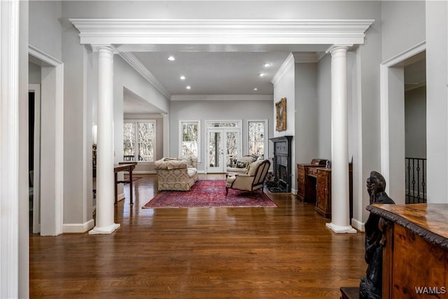 living area with wood finished floors, baseboards, ornate columns, recessed lighting, and a fireplace