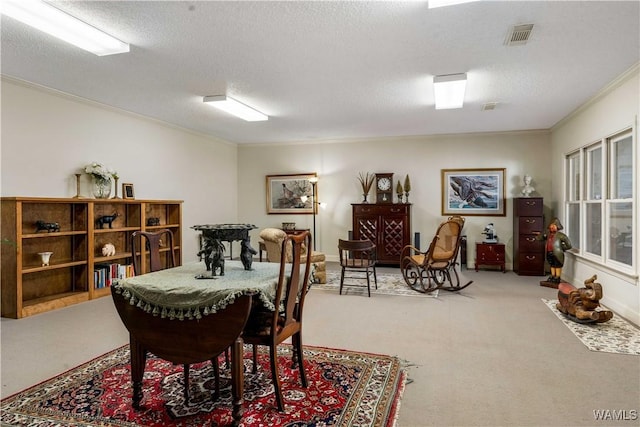 dining space featuring a textured ceiling, carpet, visible vents, and ornamental molding