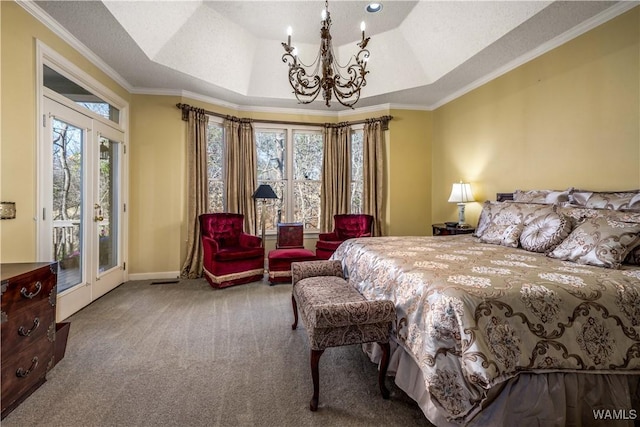 bedroom featuring ornamental molding, access to outside, a tray ceiling, carpet floors, and a chandelier