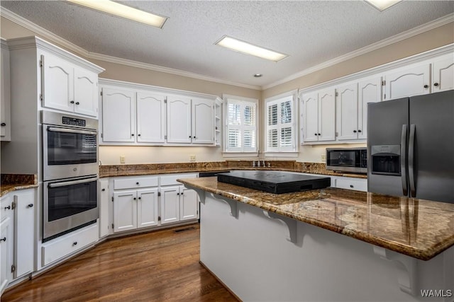 kitchen with white cabinetry, a kitchen breakfast bar, dark wood finished floors, and appliances with stainless steel finishes