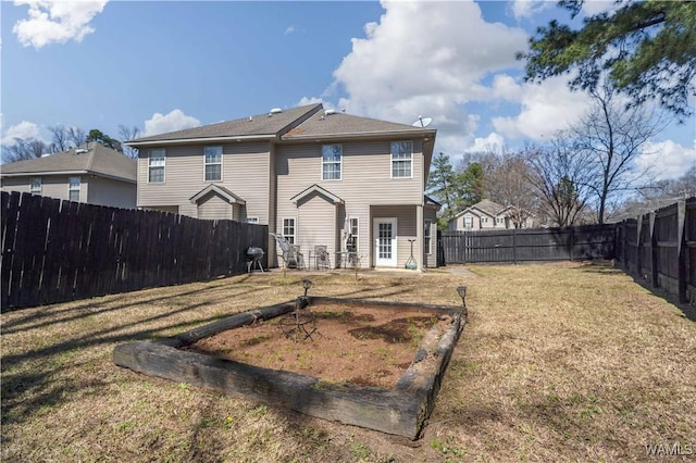 rear view of house featuring a yard and a fenced backyard