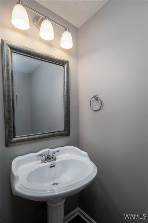 bathroom with a sink and a textured ceiling