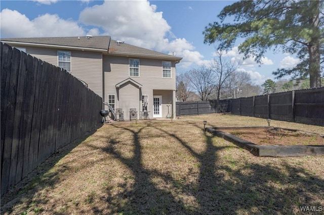 back of house featuring a yard and a fenced backyard