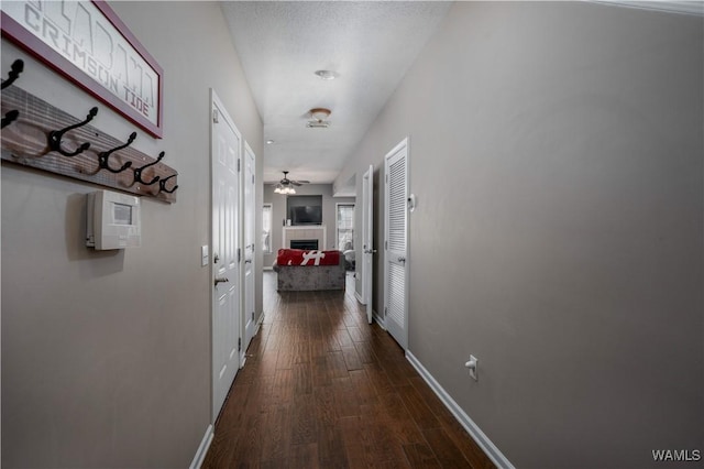 corridor with baseboards and dark wood-style flooring