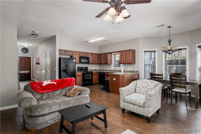 living area with visible vents, baseboards, a textured ceiling, and dark wood finished floors