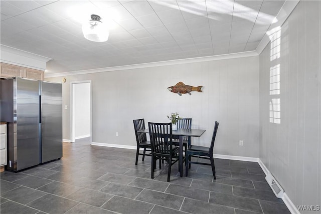 tiled dining room featuring crown molding